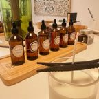 Atelier créatif Tahiti Candles avec flacons de parfums ambrés et bougie artisanale en cire de soja en préparation