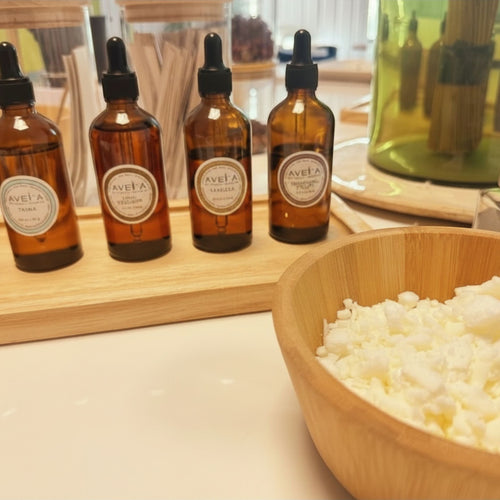 Atelier créatif Tahiti Candles avec flacons de parfums ambrés et bol de cire de soja naturelle pour bougies artisanales