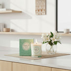 Bougie parfumée Tahiti Candles au jasmin dans un pot en verre avec sa boîte décorative sur un comptoir en bois
