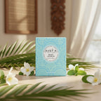 Bougie parfumée Tahiti Candles Mint Jasmin 80g dans son emballage bleu décoré de motifs polynésiens avec fleurs de jasmin
