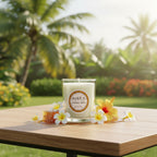 Bougie parfumée Tahiti Candles Honey Bee 80g en pot de verre, décorée de fleurs tropicales et de miel sur une table.