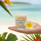 Bougie parfumée Tahiti Candles Neroli Bergamot 80g en pot de verre, tenue en main avec une fleur de tiaré en arrière-plan