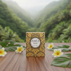 Bougie parfumée Tahiti Candles Enata 80g avec motifs polynésiens, cire naturelle, posée sur une table en bois.